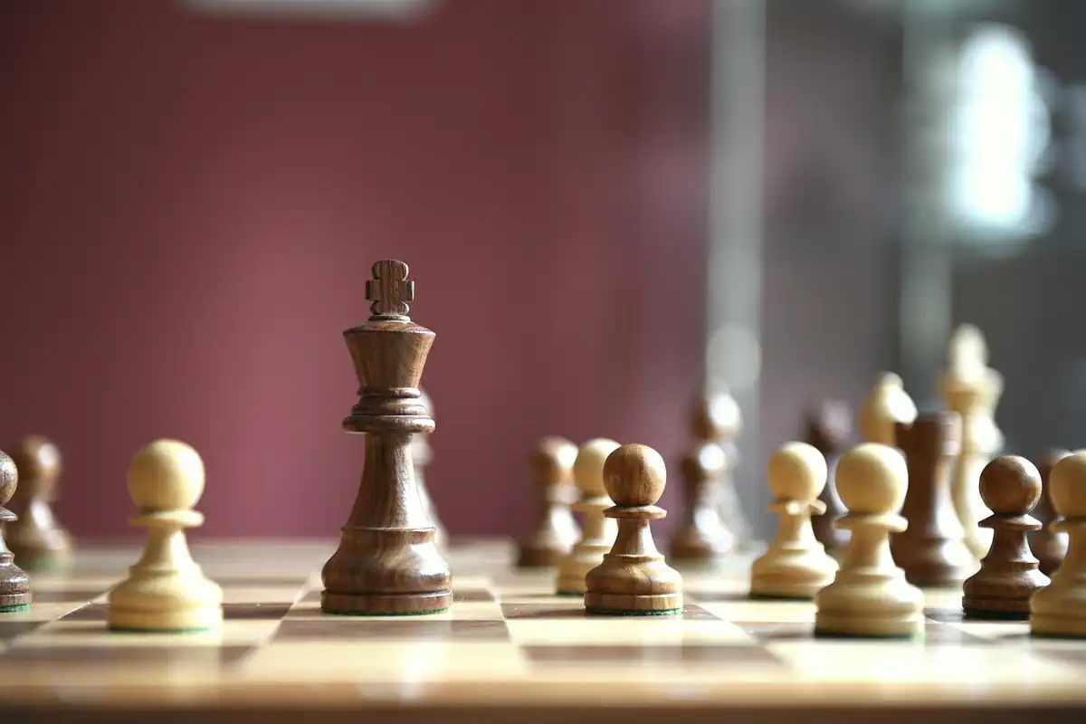 Piese de șah din lemn văzute de aproape pe tabla de joc, simbol al strategiei în conducere