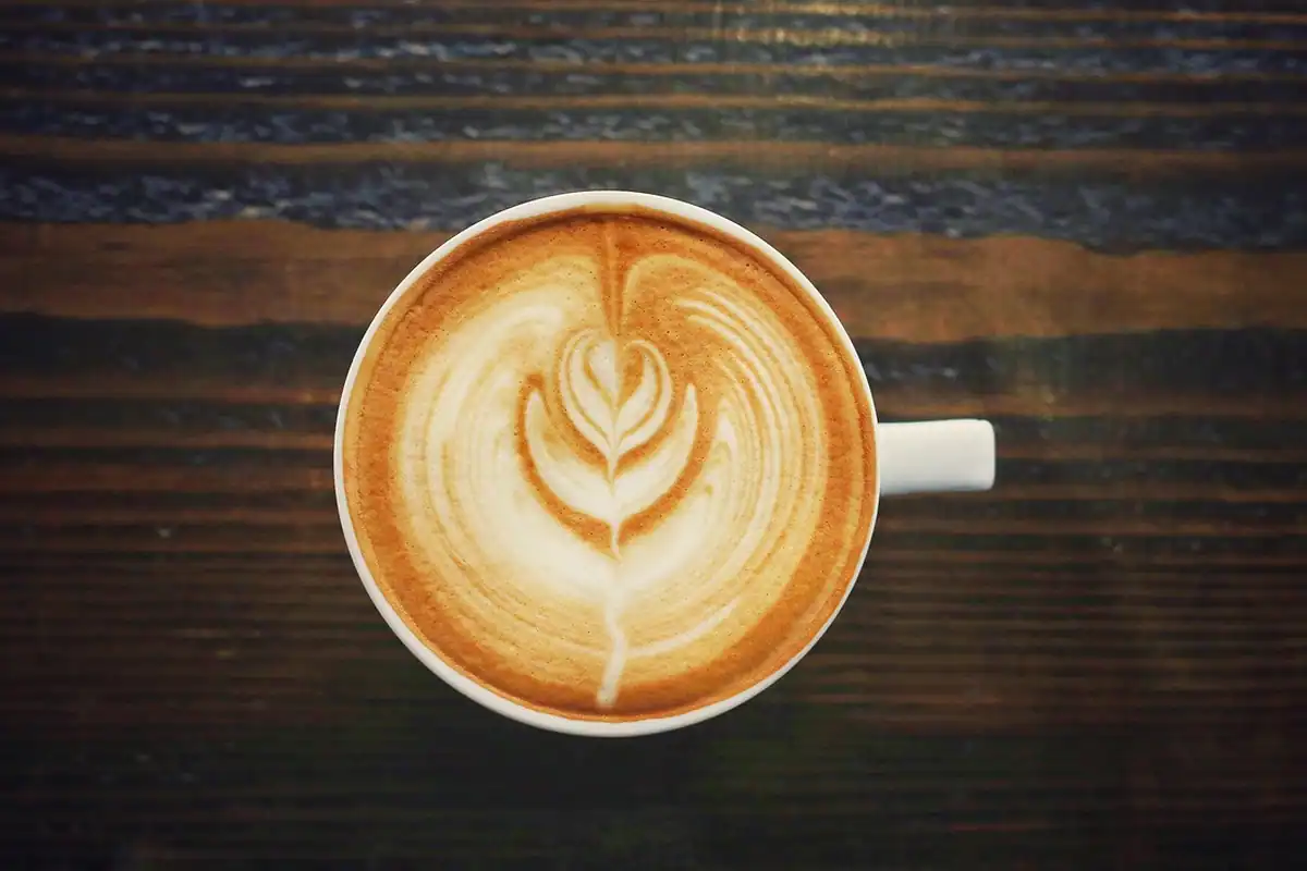 Agendă tipărită și cești de cafea pe masă, pregătite pentru ședința de lansare a proiectului